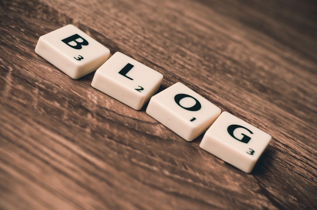 Scrabble letters that spell BLOG on on a wooden table background